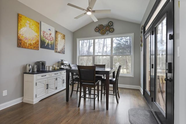 dining room featuring dark wood-style floors, baseboards, vaulted ceiling, and a wealth of natural light