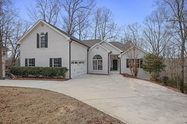 view of front of house featuring a garage, concrete driveway, and brick siding