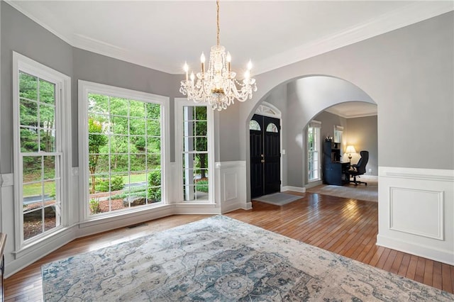 206 Kingsley Way, Woodstock, GA 30188 - entrance foyer with ornamental molding, hardwood / wood-style floors, a chandelier, arched walkways, and wainscoting