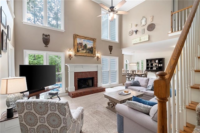206 Kingsley Way, Woodstock, GA 30188 - carpeted living room featuring a high ceiling, stairway, a ceiling fan, and a brick fireplace