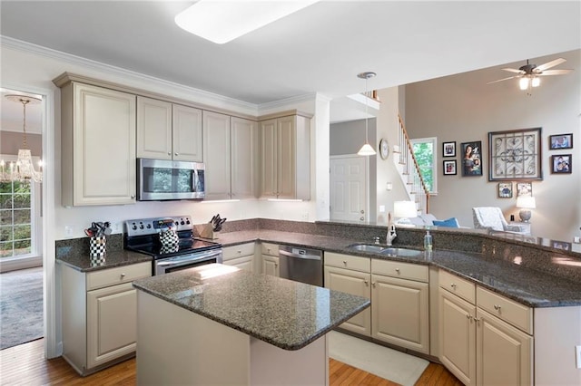 206 Kingsley Way, Woodstock, GA 30188 - kitchen with appliances with stainless steel finishes, a sink, light wood-style floors, a kitchen island, and dark stone countertops