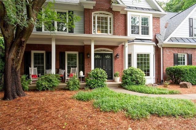 206 Kingsley Way, Woodstock, GA 30188 - view of front of property featuring covered porch, brick siding, a standing seam roof, and a shingled roof