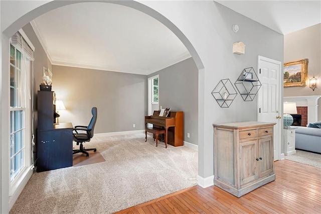 206 Kingsley Way, Woodstock, GA 30188 - home office featuring ornamental molding, baseboards, light wood-style flooring, arched walkways, and a fireplace