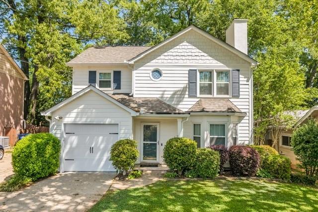 1123 Seaboard Ave NW, Atlanta, GA 30318 - view of front facade featuring a front lawn, a chimney, a garage, and driveway