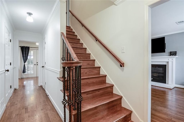 1123 Seaboard Ave NW, Atlanta, GA 30318 - stairs with baseboards, wood finished floors, ornamental molding, and a glass covered fireplace