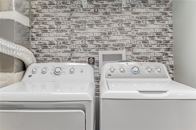1123 Seaboard Ave NW, Atlanta, GA 30318 - clothes washing area with separate washer and dryer, laundry area, and brick wall