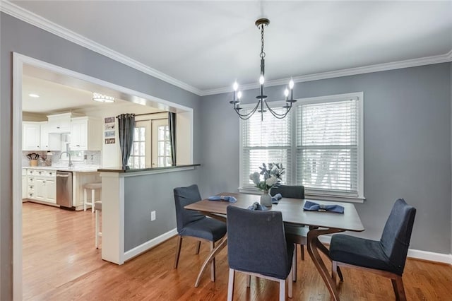 1123 Seaboard Ave NW, Atlanta, GA 30318 - dining area with baseboards, a notable chandelier, light wood-style flooring, and ornamental molding