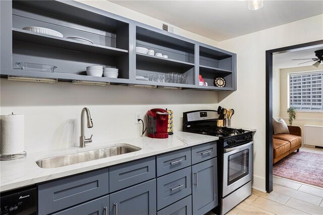 kitchen with gas stove, light stone countertops, sink, and black dishwasher