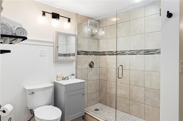 bathroom with toilet, an enclosed shower, and vanity