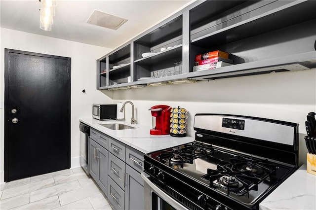 kitchen with gray cabinets, light stone countertops, sink, and appliances with stainless steel finishes