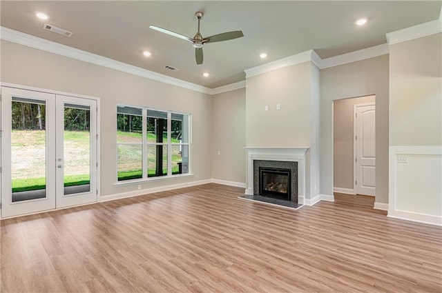 unfurnished living room with crown molding, a high end fireplace, light hardwood / wood-style floors, and french doors