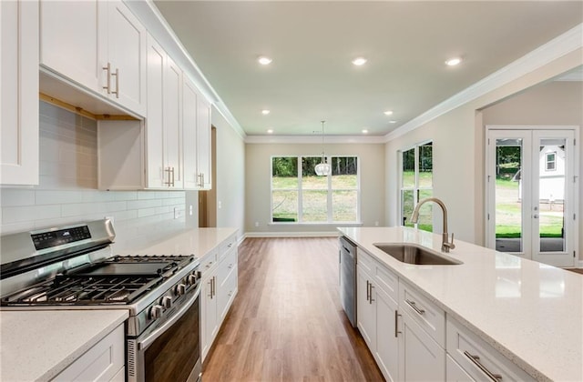 kitchen featuring sink, decorative light fixtures, white cabinets, and appliances with stainless steel finishes