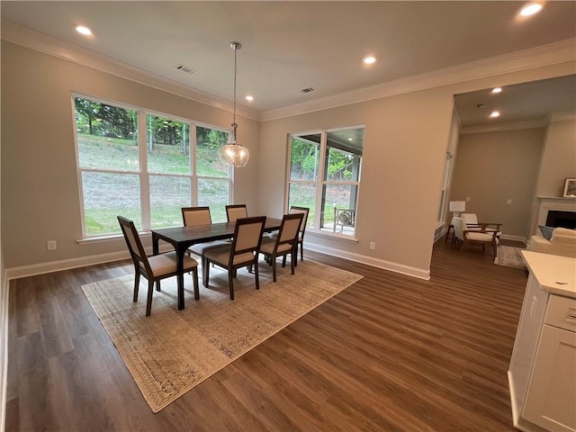 dining room featuring crown molding, plenty of natural light, dark wood-type flooring, and a chandelier