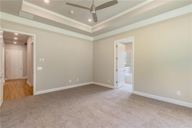 carpeted spare room featuring ornamental molding, ceiling fan, and a tray ceiling