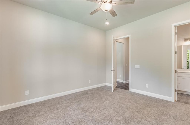 unfurnished bedroom featuring ensuite bath, carpet floors, and ceiling fan