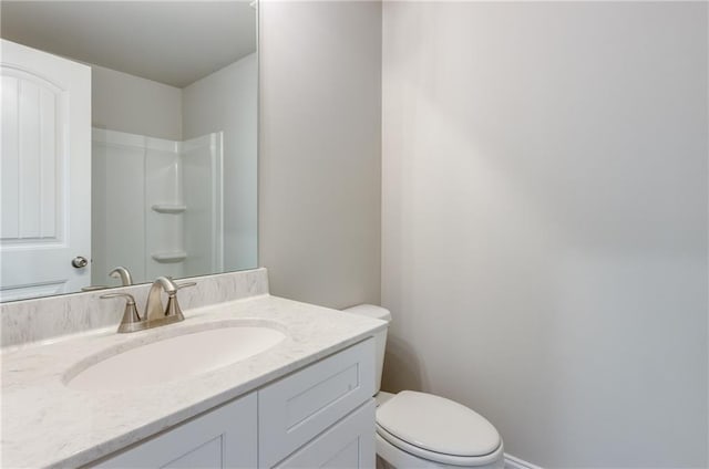 bathroom with vanity, toilet, and a shower