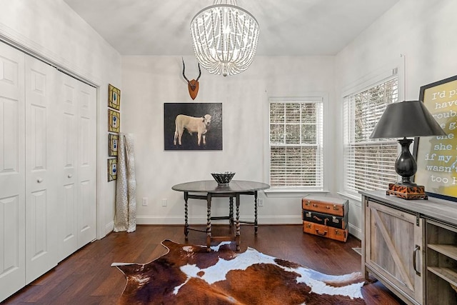 interior space featuring a healthy amount of sunlight, dark wood-type flooring, and a chandelier