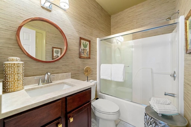 full bathroom featuring toilet, wooden walls, vanity, and shower / bath combination with glass door