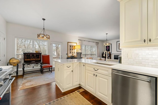 kitchen with stainless steel appliances, hanging light fixtures, sink, and kitchen peninsula