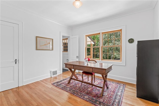 office with ornamental molding and light hardwood / wood-style floors