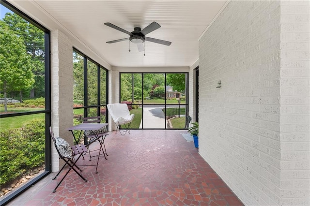 unfurnished sunroom with ceiling fan