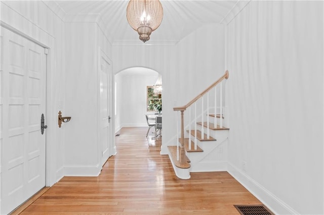 foyer featuring crown molding and light hardwood / wood-style flooring