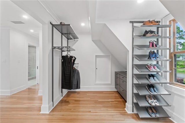 walk in closet with light hardwood / wood-style flooring