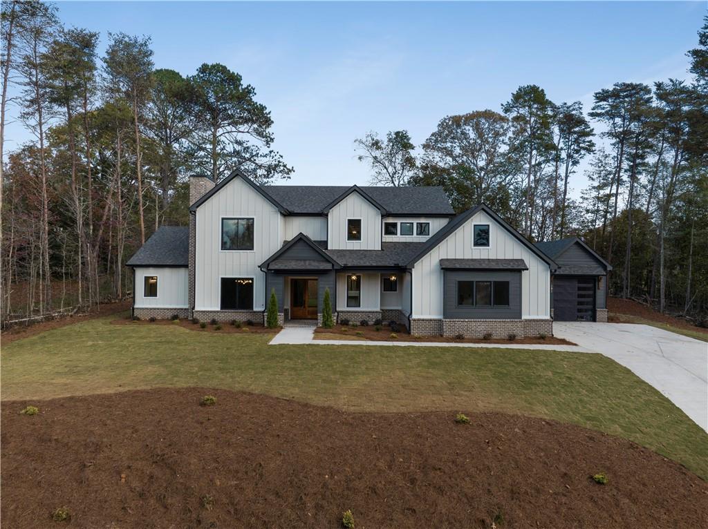 modern inspired farmhouse featuring a front lawn and a garage