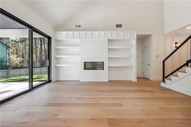 4815 Price Rd, Gainesville, GA 30506 - unfurnished living room featuring high vaulted ceiling, plenty of natural light, light wood finished floors, and stairs