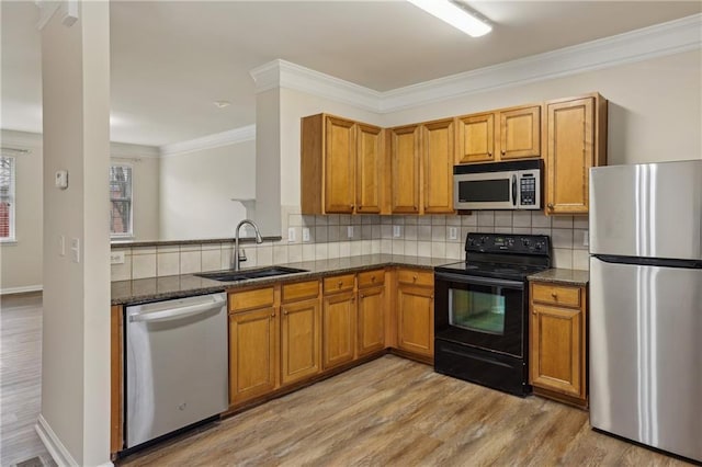 kitchen with appliances with stainless steel finishes, sink, dark stone countertops, decorative backsplash, and crown molding