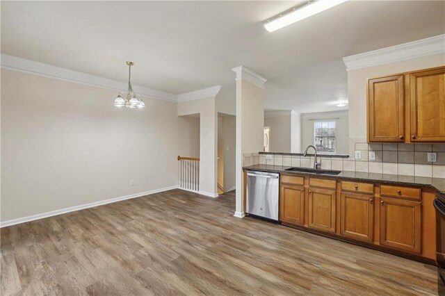 kitchen featuring decorative light fixtures, dishwasher, wood-type flooring, sink, and backsplash