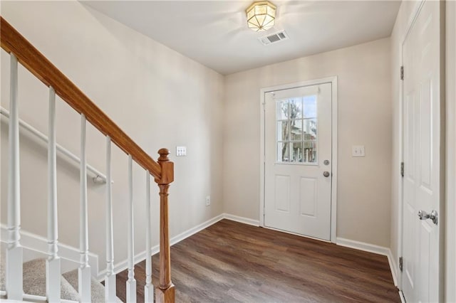 foyer entrance featuring stairs, dark wood-type flooring, baseboards, and visible vents