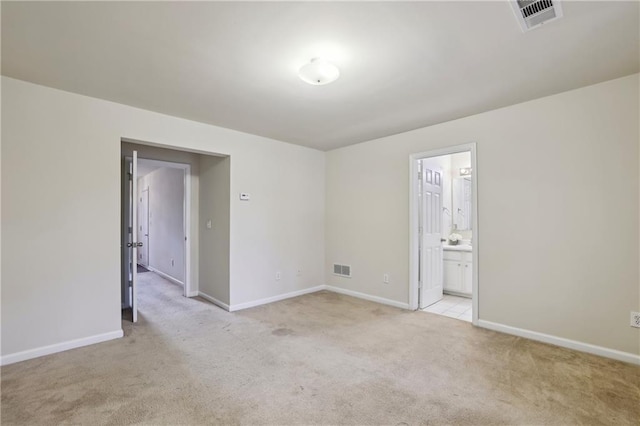 unfurnished room with visible vents, light carpet, and baseboards