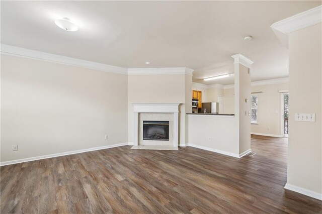 unfurnished living room with ornamental molding, dark hardwood / wood-style floors, and ornate columns