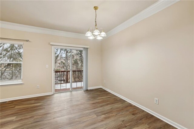 unfurnished room featuring dark hardwood / wood-style flooring, ornamental molding, and a chandelier