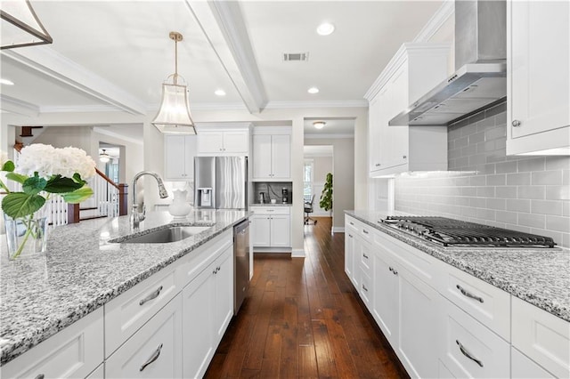 kitchen with visible vents, wall chimney exhaust hood, dark wood-style flooring, stainless steel appliances, and a sink