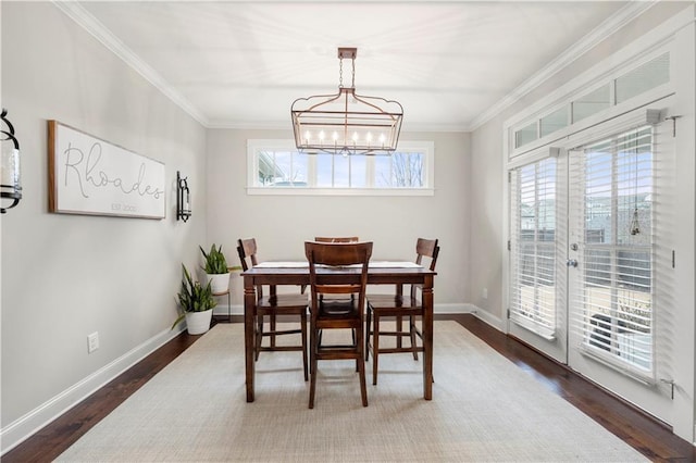 dining area featuring baseboards, wood finished floors, and crown molding