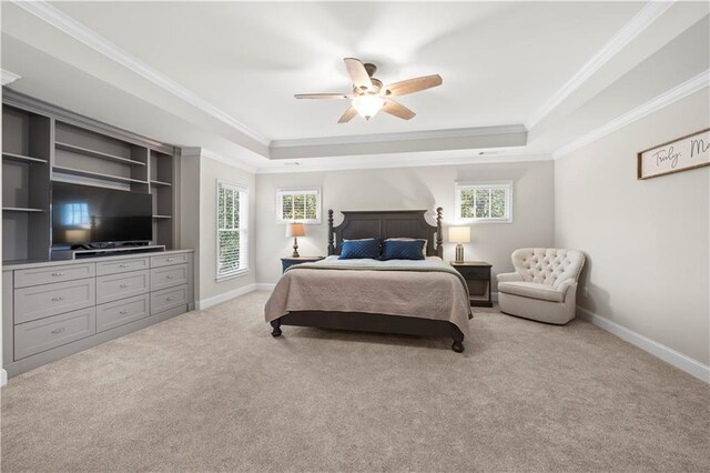 bedroom with baseboards, a tray ceiling, multiple windows, and light colored carpet