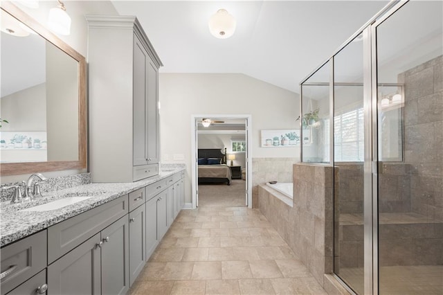 full bath with connected bathroom, a stall shower, vaulted ceiling, and vanity