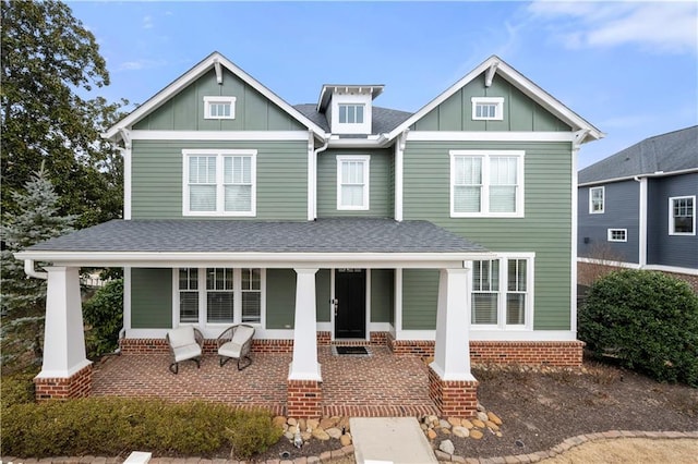 view of front of property with a shingled roof, a porch, and board and batten siding