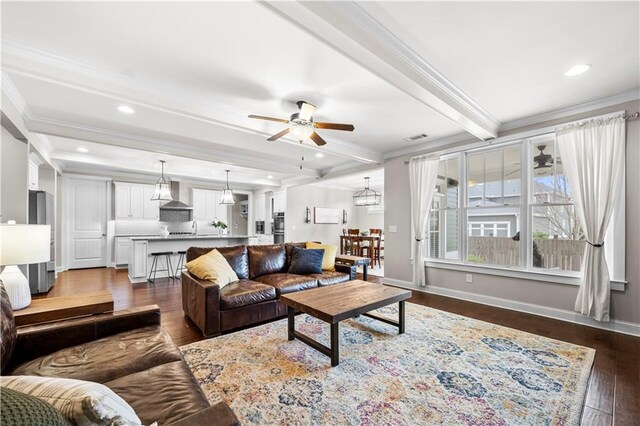 living room with visible vents, baseboards, ornamental molding, beam ceiling, and dark wood-style floors