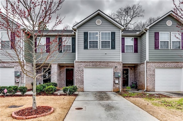 townhome / multi-family property with driveway, brick siding, and an attached garage