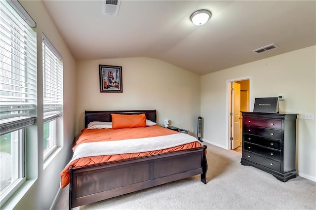 bedroom featuring light carpet, baseboards, visible vents, and vaulted ceiling