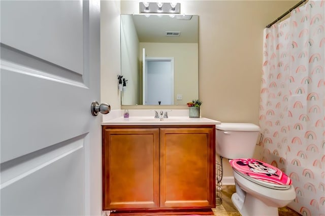 bathroom with toilet, visible vents, a shower with shower curtain, and vanity