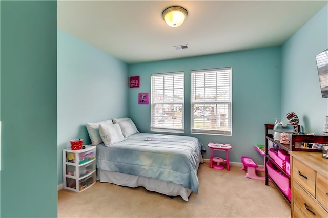 bedroom featuring baseboards, visible vents, and light colored carpet