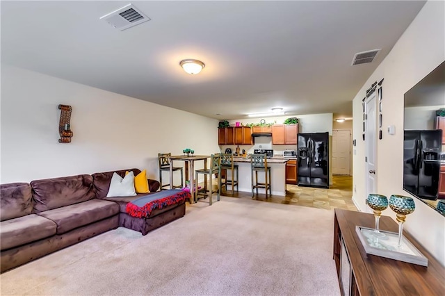 living area featuring light carpet and visible vents