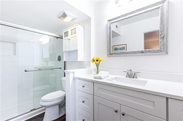 bathroom featuring toilet, an enclosed shower, and vanity