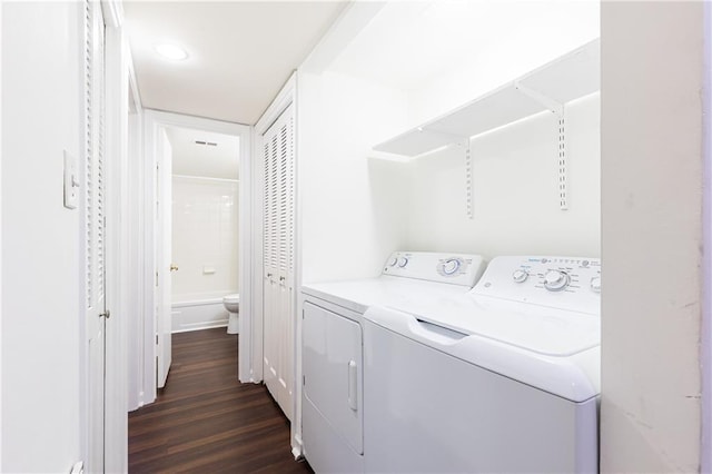 laundry area with dark hardwood / wood-style flooring and washing machine and clothes dryer