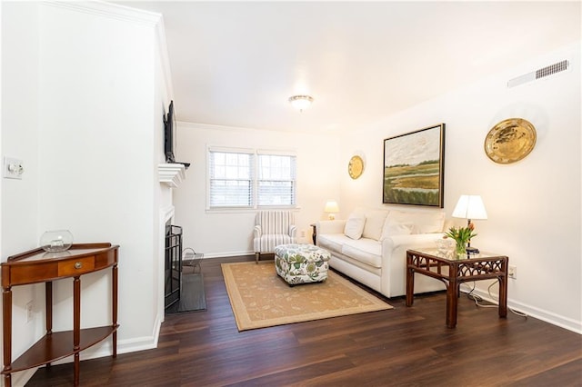 living room featuring dark hardwood / wood-style floors and ornamental molding