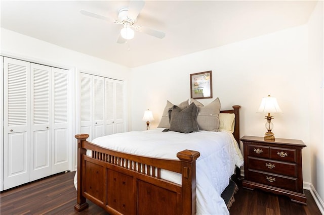 bedroom featuring ceiling fan, dark hardwood / wood-style flooring, and two closets